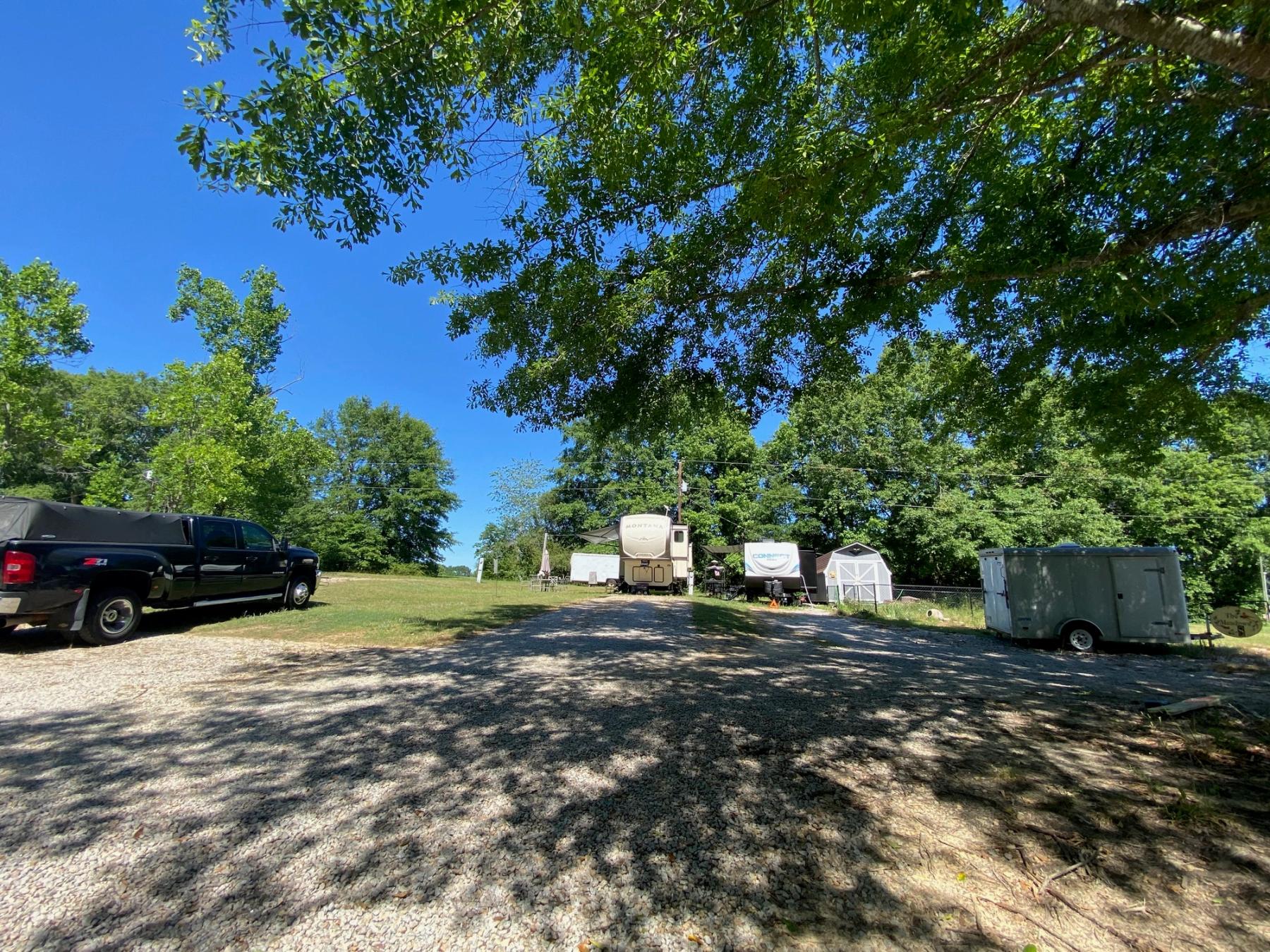 Shaded gravel lane running through Ivy Hill Campground under mature oak trees