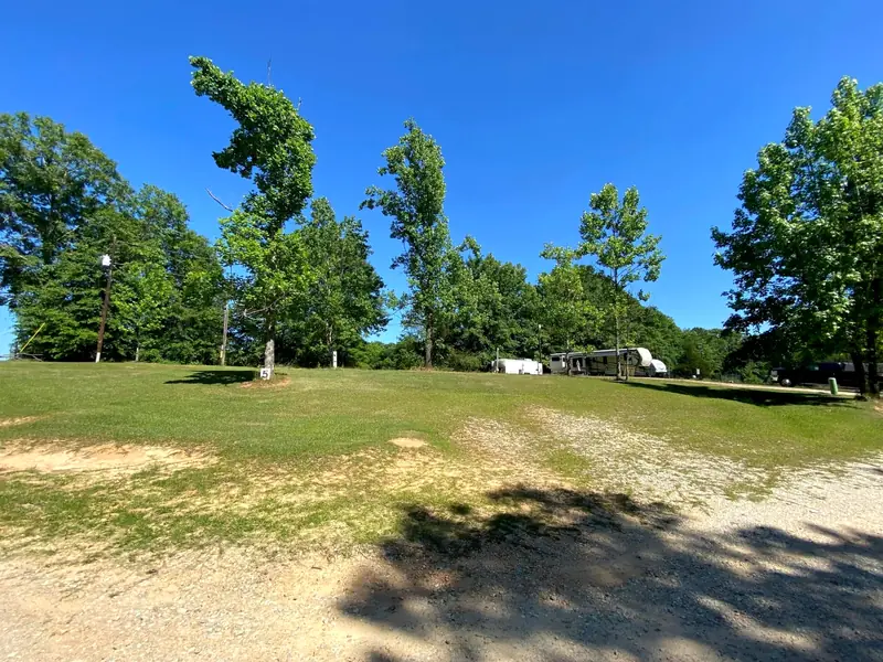 Open grass lots with shade trees and campers along the tree line